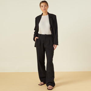 Front view of model wearing the bonded thermal pleated pants in black.