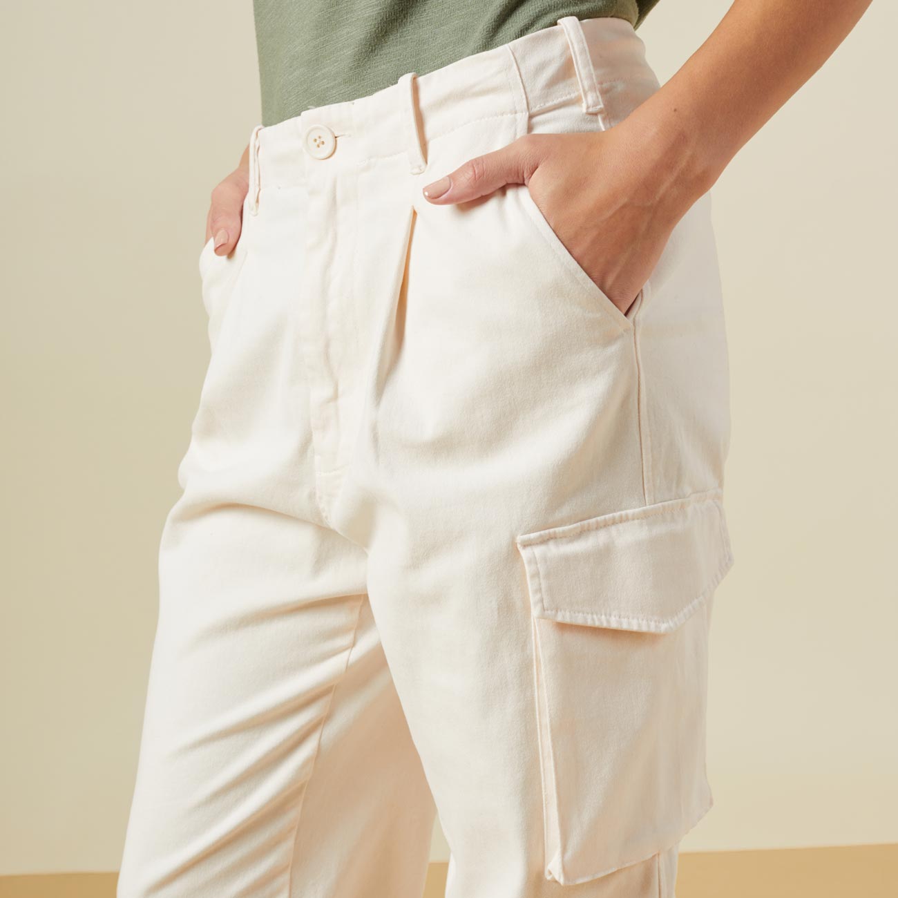 Close up view of model wearing the utility pants in off white.