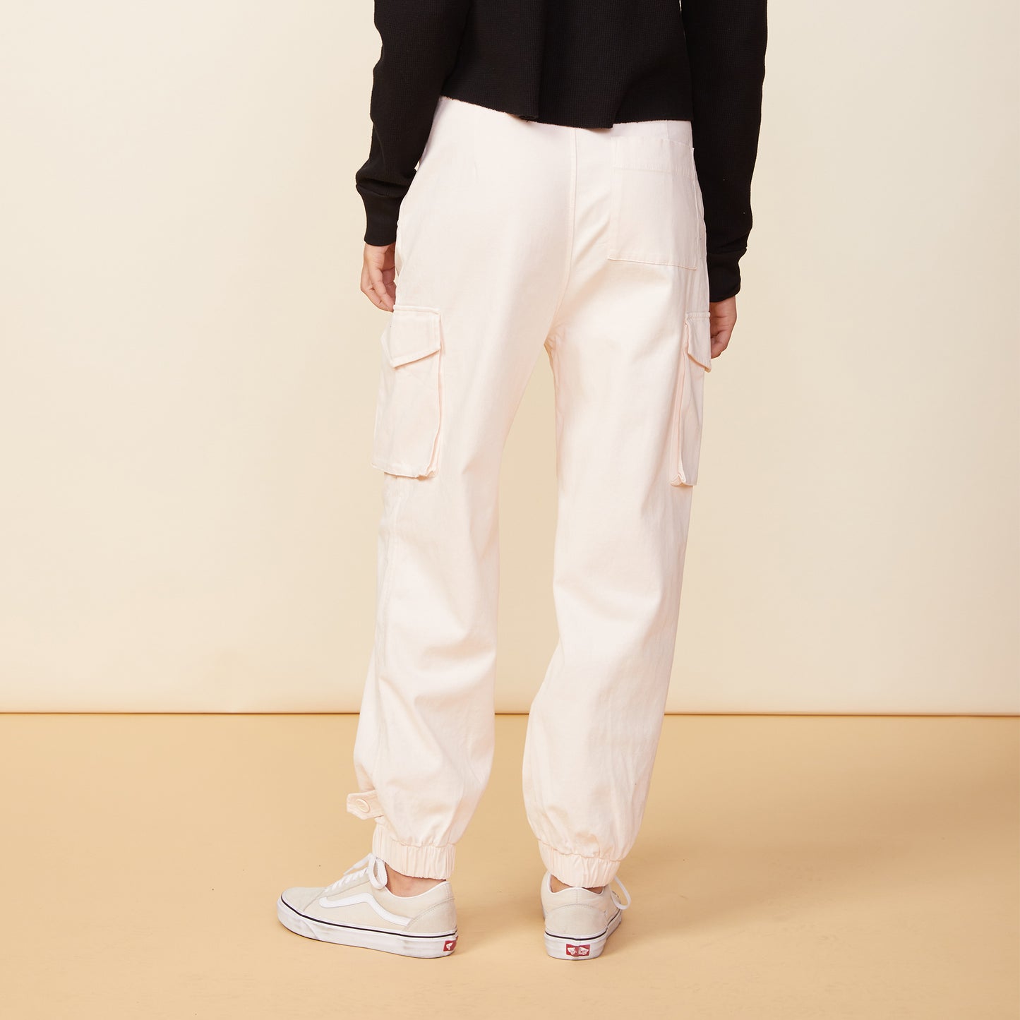 Back view of model wearing the utility pants in off white.