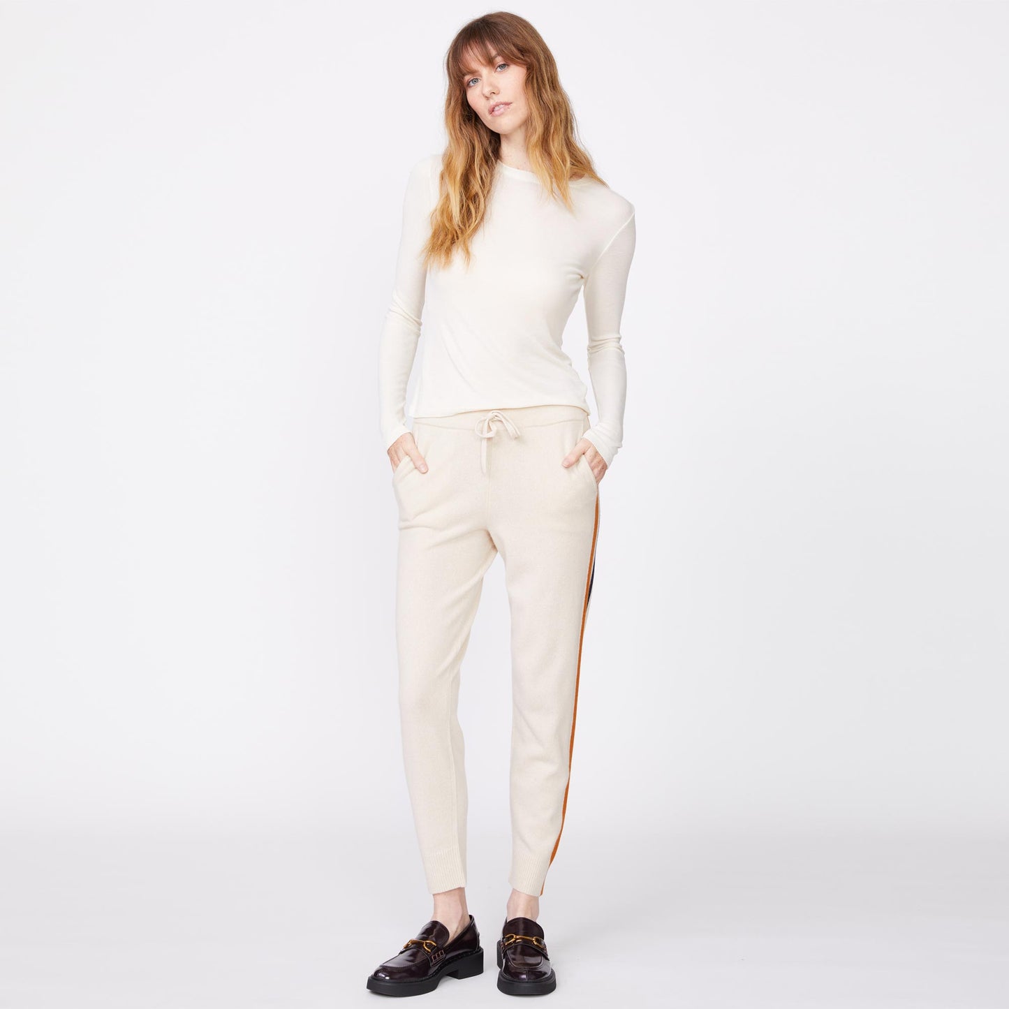 Front view of the model wearing the wool cashmere sweater cuffed sweats in off white.