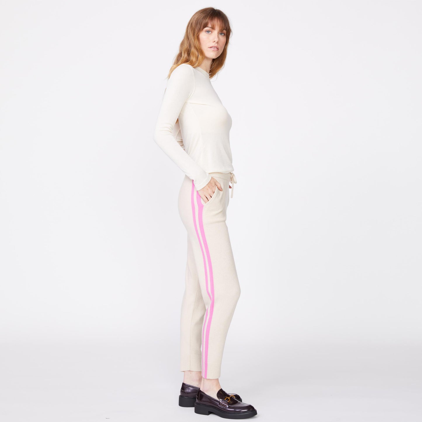 Side view of the model wearing the wool cashmere sweater cuffed sweats in off white.