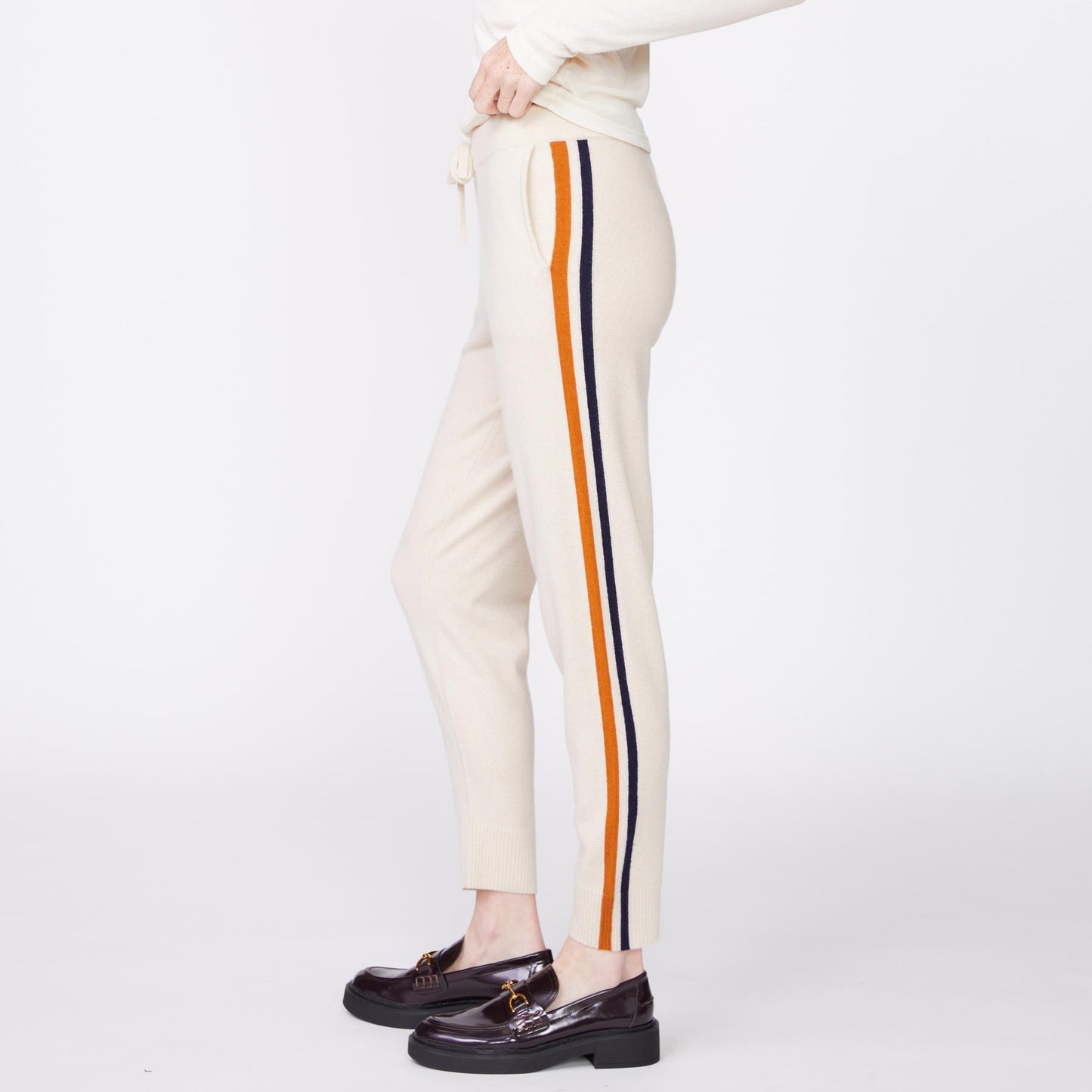 Side view of the model wearing the wool cashmere sweater cuffed sweats in off white.
