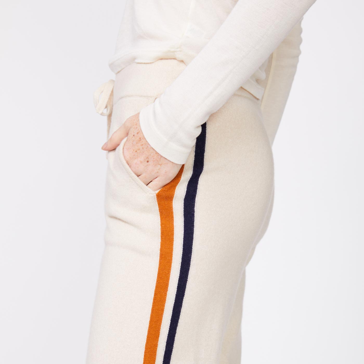 Close up side view of the model wearing the wool cashmere sweater cuffed sweats in off white.