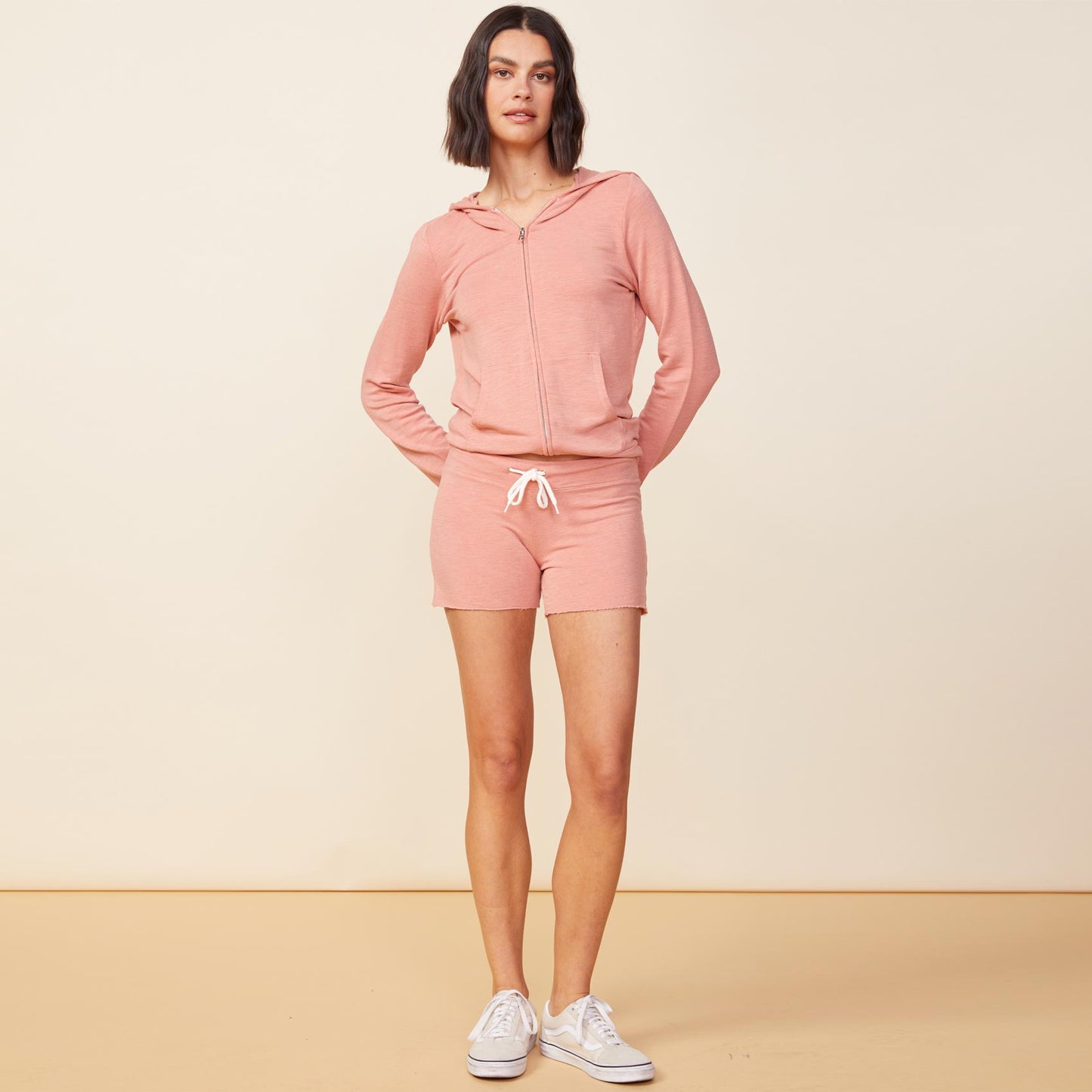Front view of model wearing the supersoft zip up hoody in faded coral.