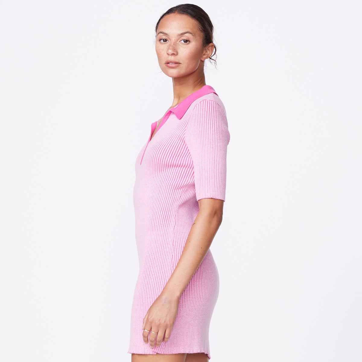 Side view of model wearing the polo sweater dress in bubble gum.