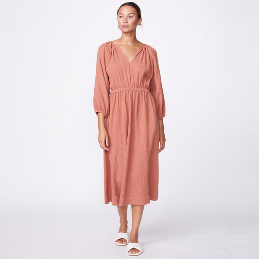 Front view of model wearing the gauze open back dress in faded rust.