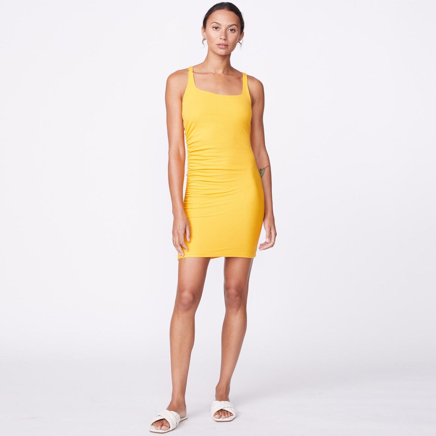 Front view of model wearing the rib square neck mini dress in marigold.
