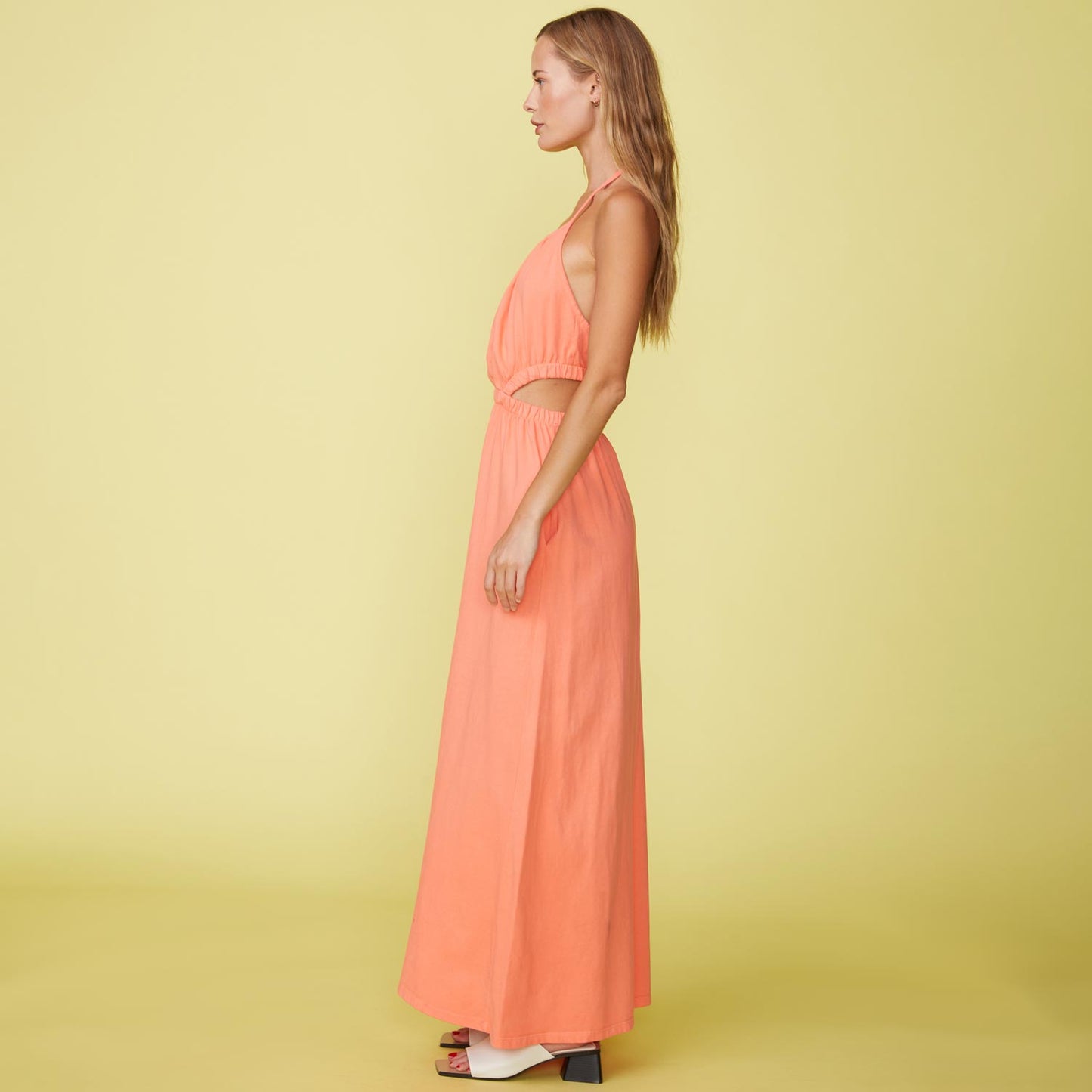 Side View of model wearing the Cut Out Halter Dress in Georgia Peach.