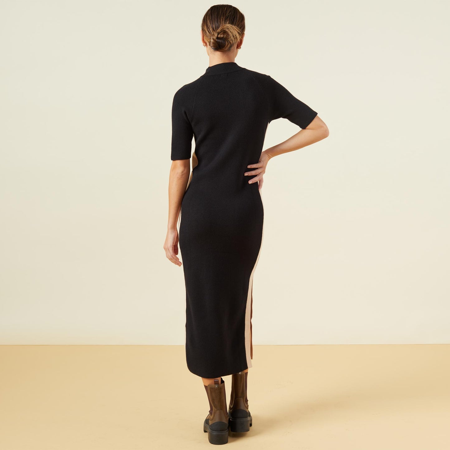 Back view of model wearing the supersoft sweater knit color block dress in black/off white.