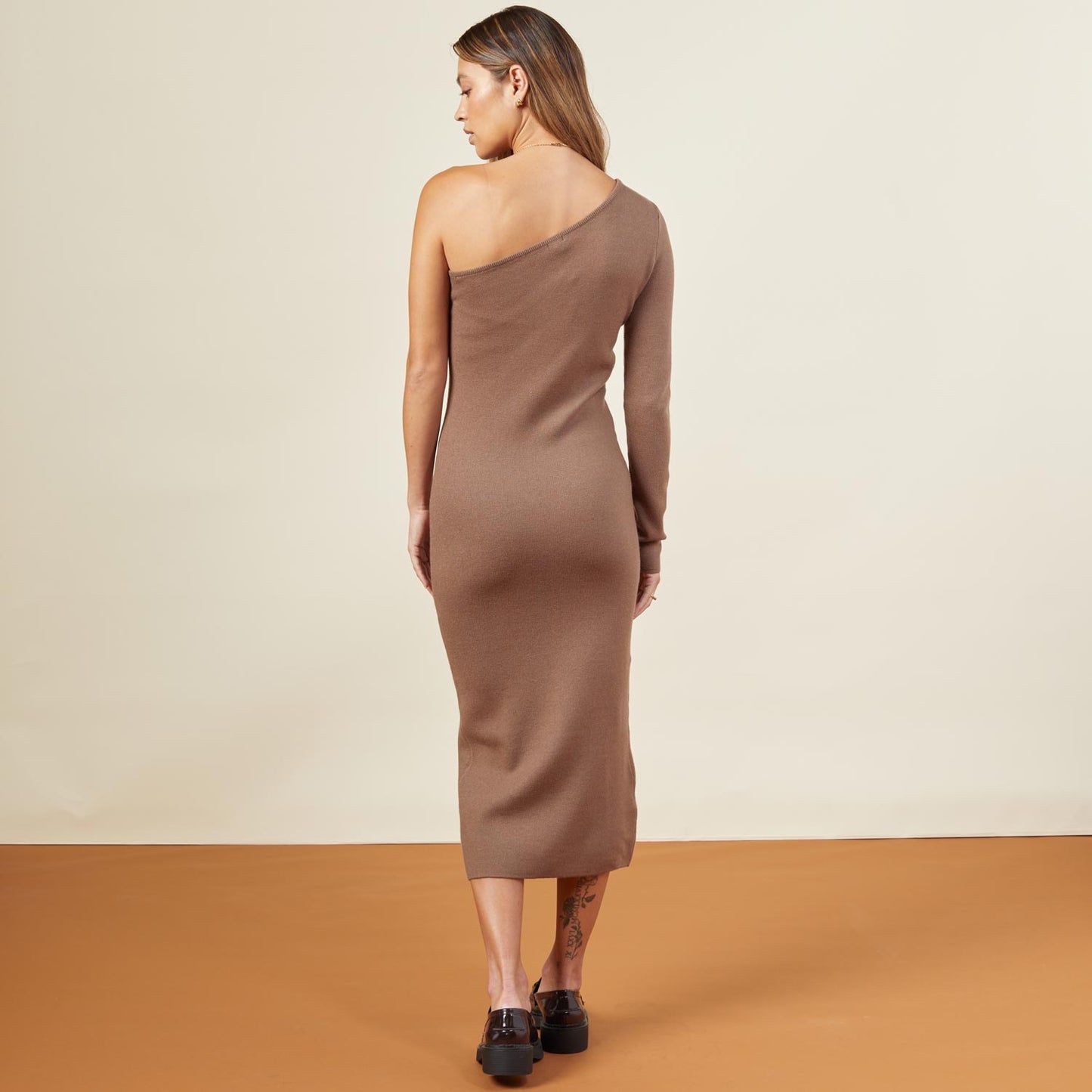 Back view of model wearing the supersoft sweater knit one shoulder dress in dusty cocoa.