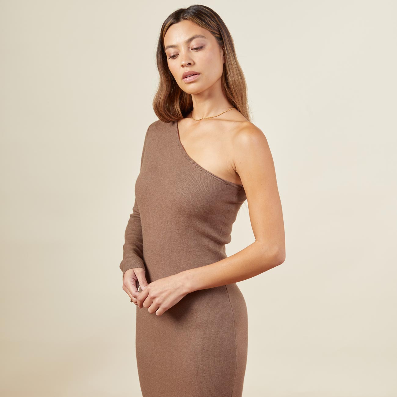 Close up view of model wearing the supersoft sweater knit one shoulder dress in dusty cocoa.