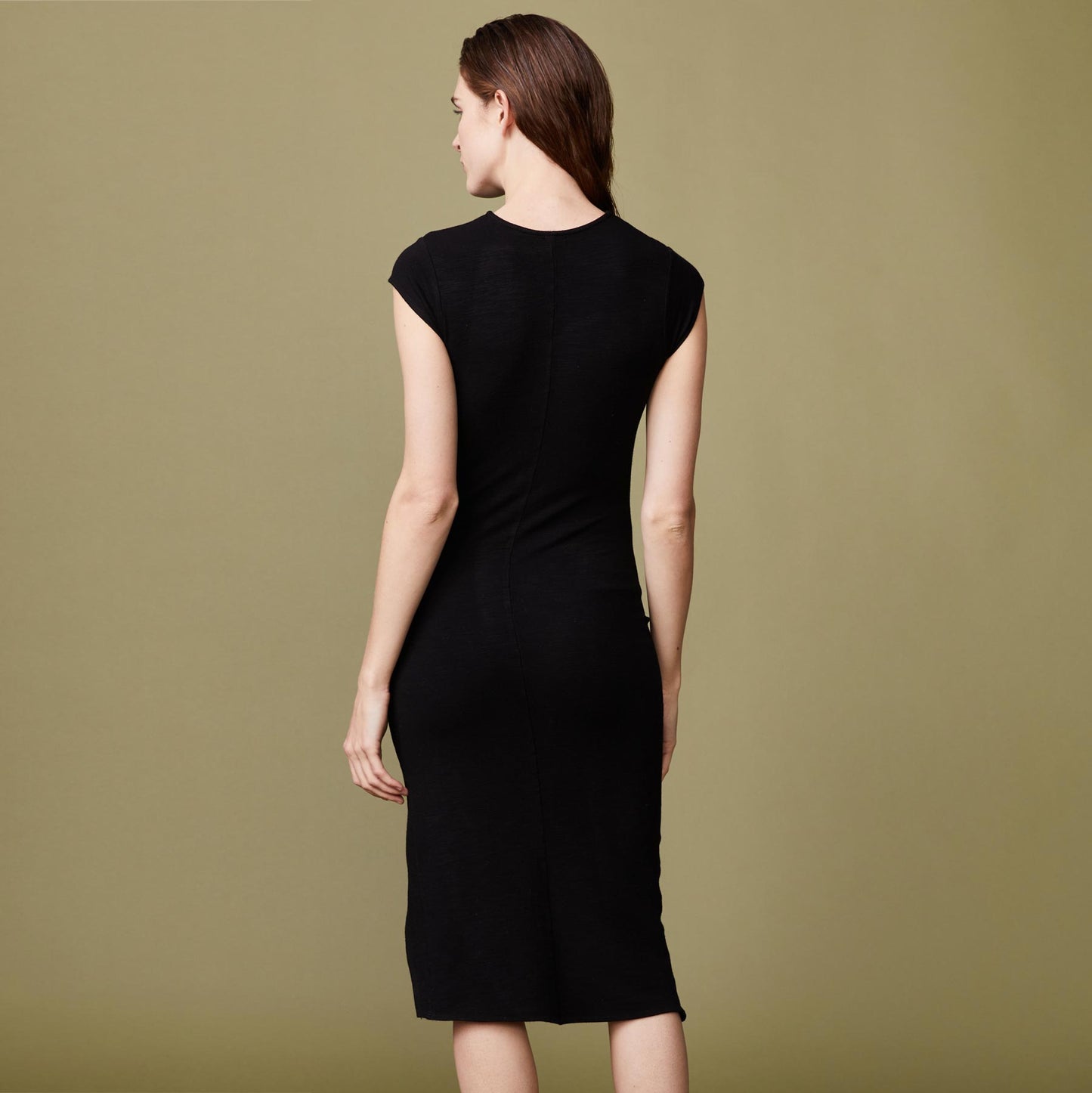 Back view of model wearing the supersoft cap sleeve shirred dress in black.