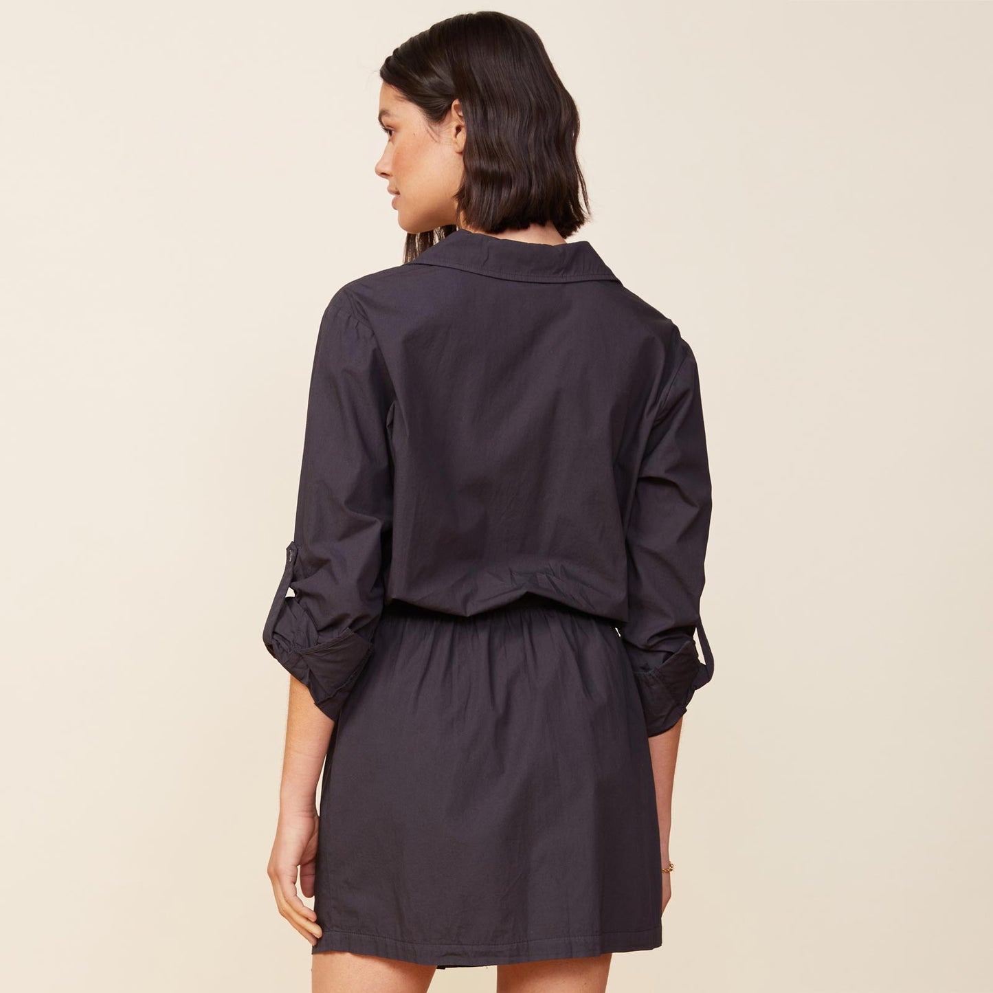 Back view of model wearing the poplin shirt dress in faded black.