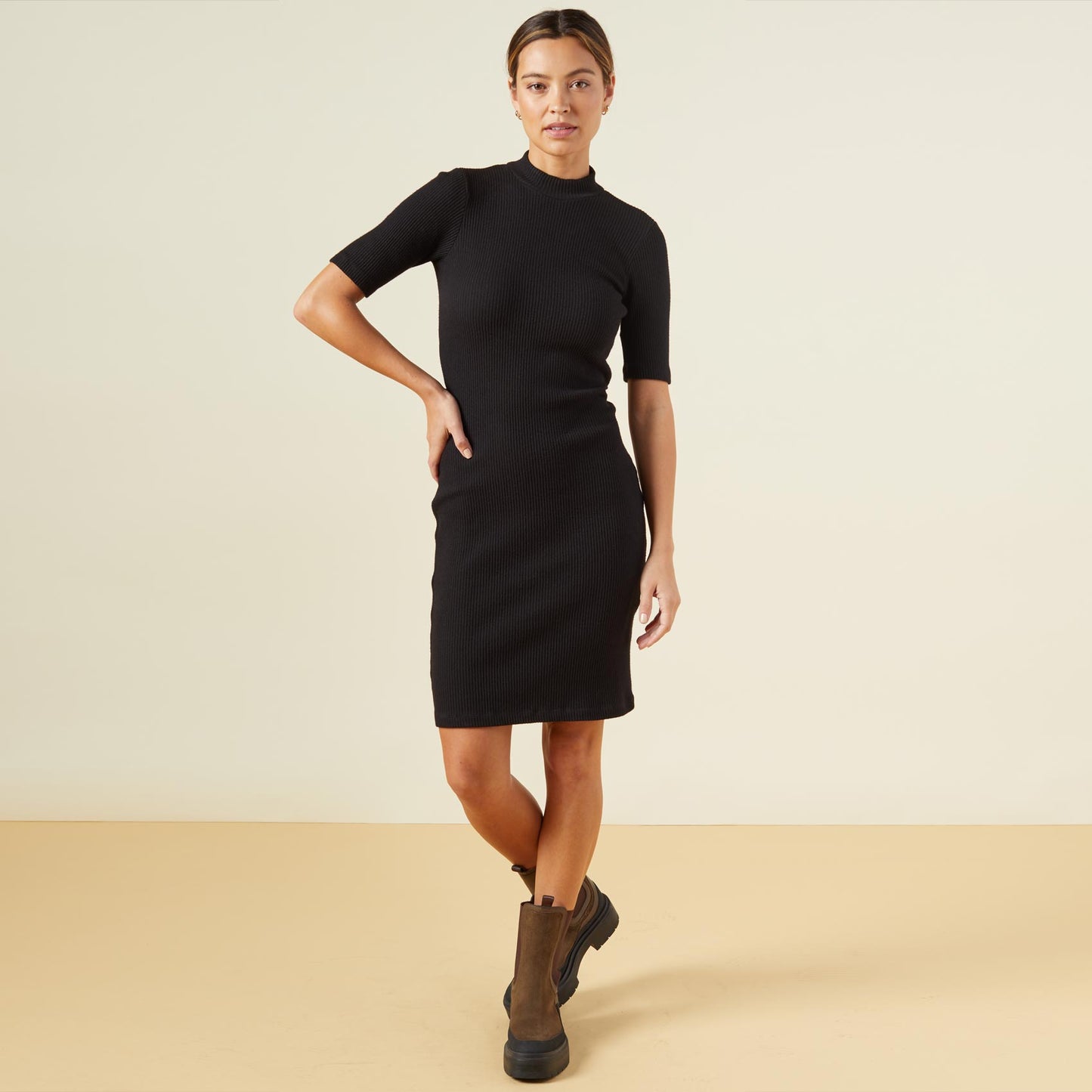 Front view of model wearing the brushed rib mock neck dress in black.