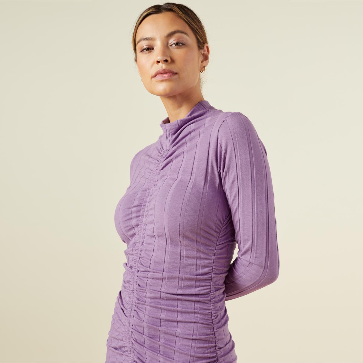 Close up view of model wearing the flat rib mock shirred dress in aster purple.