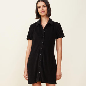 Front view of model wearing the terry cloth shirt dress in black.