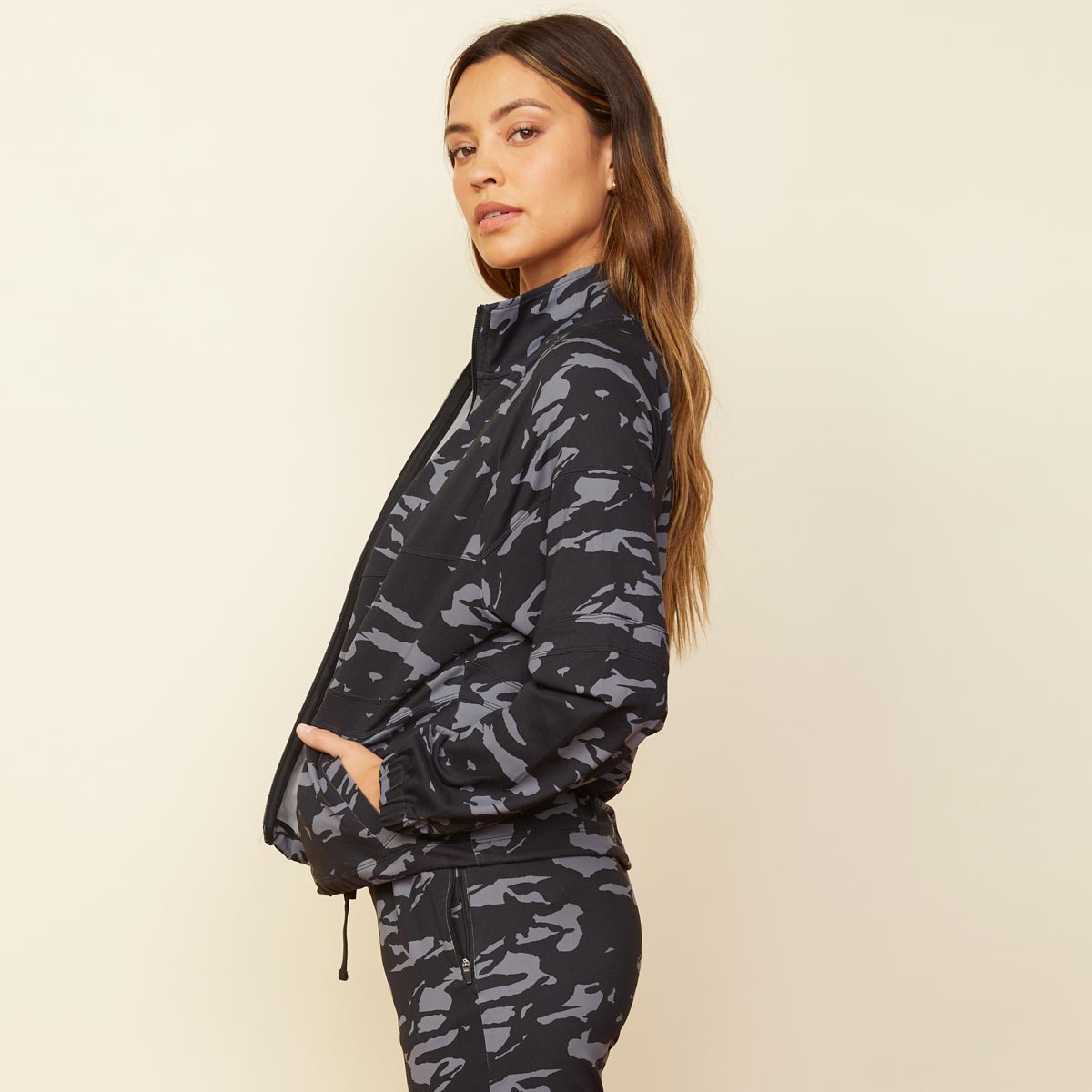 Side view of model wearing the two-tone camo movement jacket in vintage black.