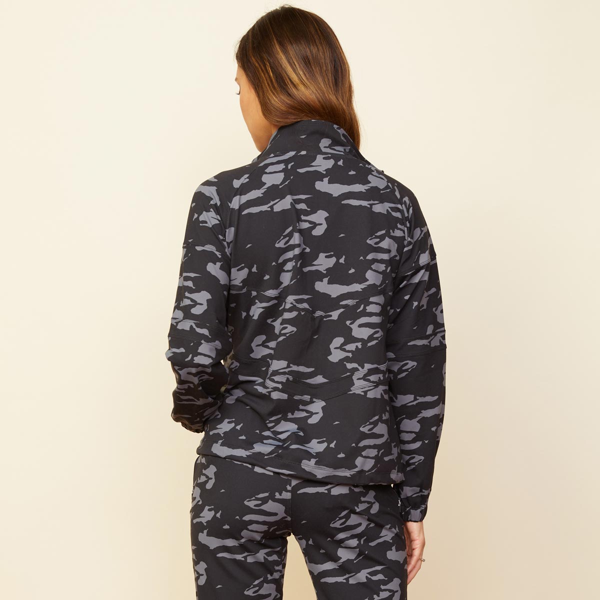 Back view of model wearing the two-tone camo movement jacket in vintage black.
