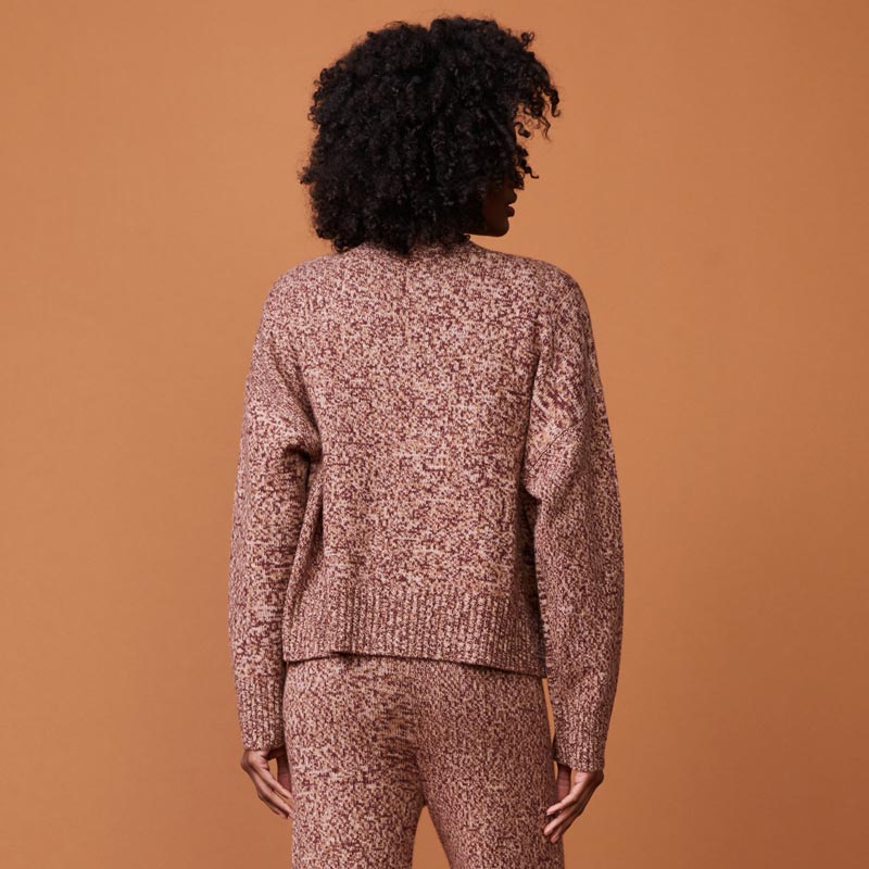 Back view of model wearing the marled oversized cardigan in pomegranate.