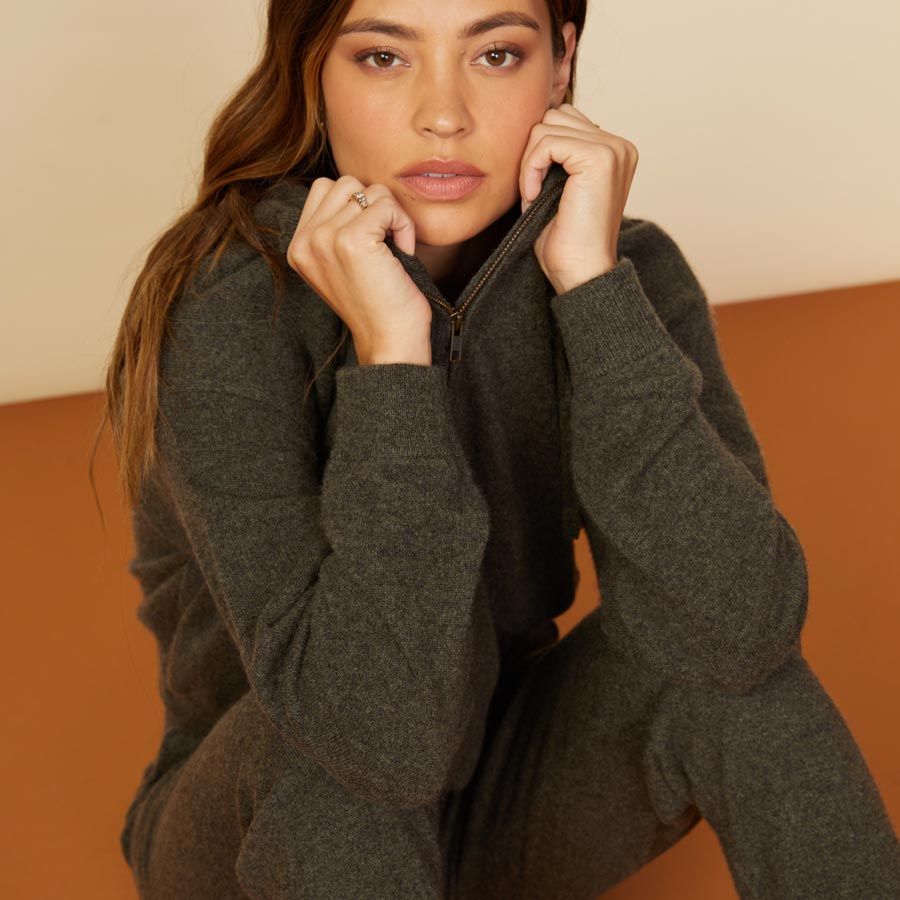 Close up view of model wearing the cashmere zip up hoody in moss.