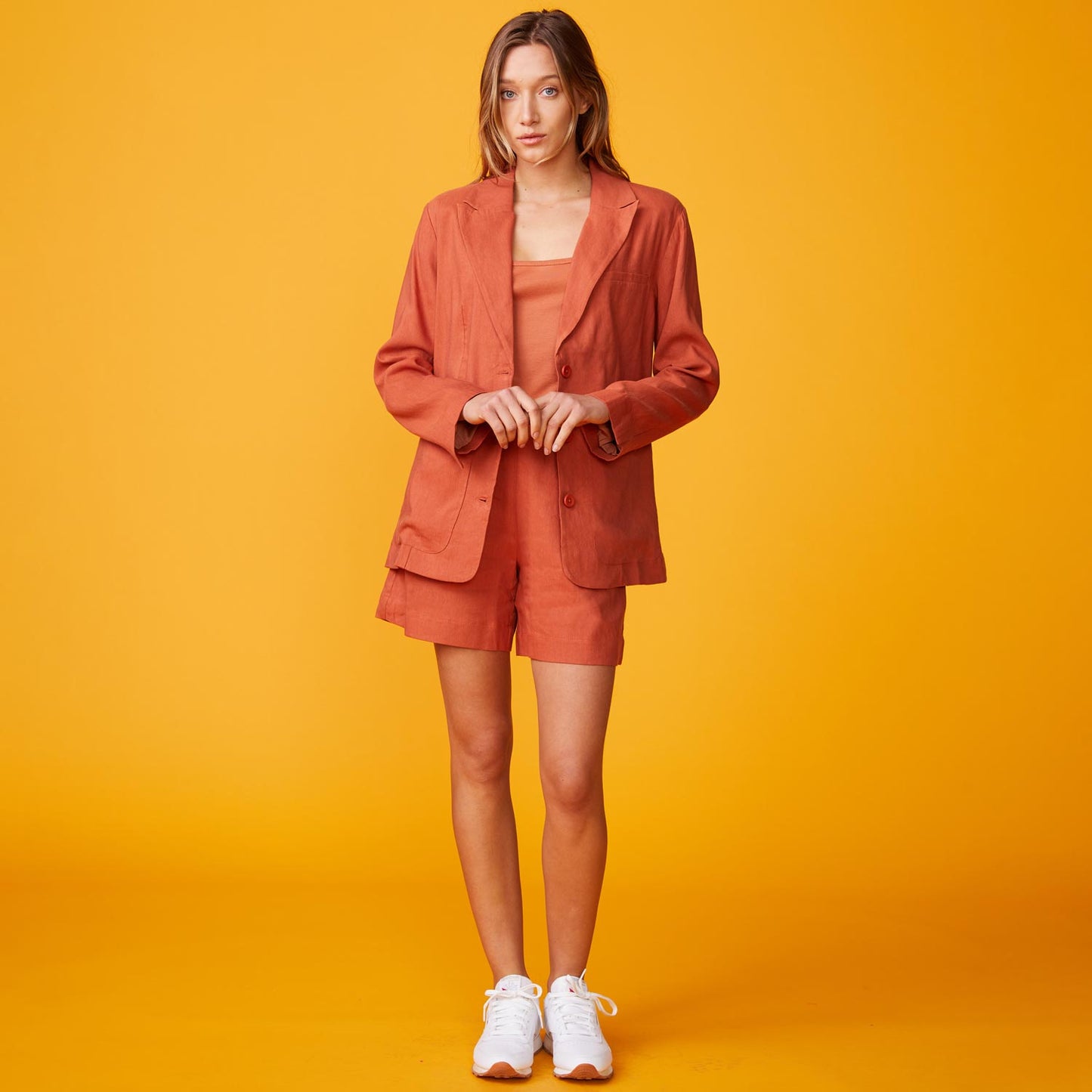 Front view of model wearing the linen oversized blazer in faded rust.