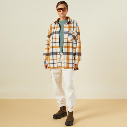 Front view of model wearing the plaid shacket in black, natural, caramel.