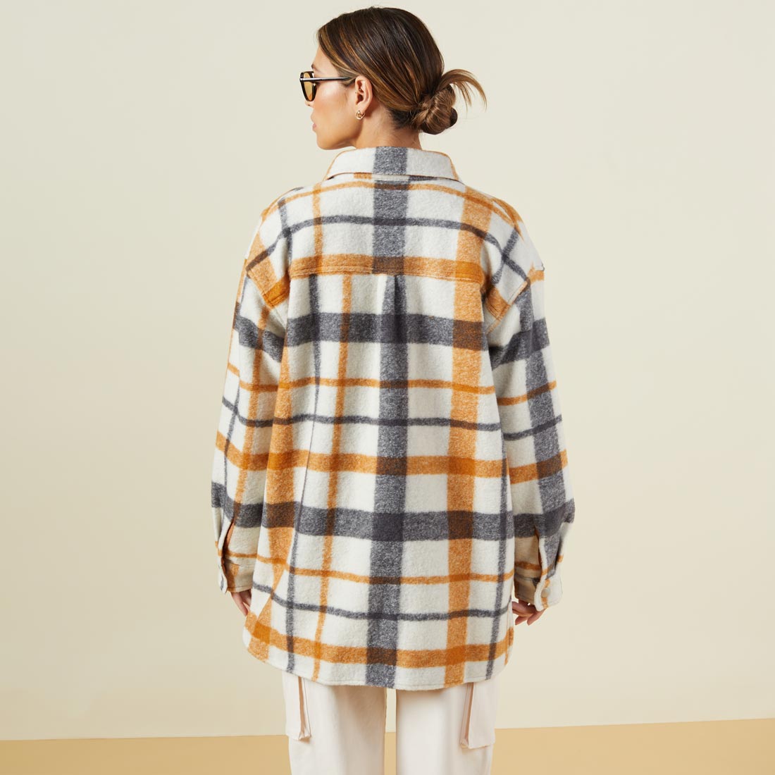 Back view of model wearing the plaid shacket in black, natural, caramel.