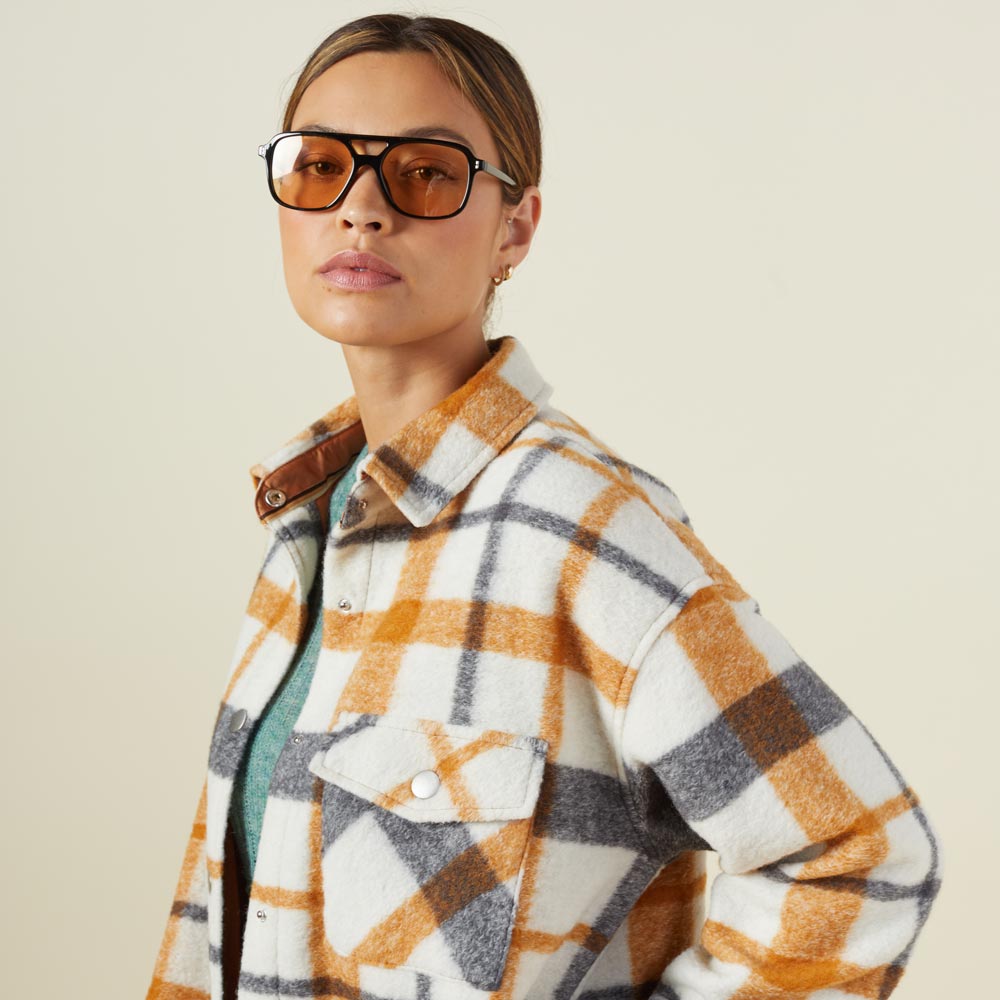 Close up view of model wearing the plaid shacket in black, natural, caramel.