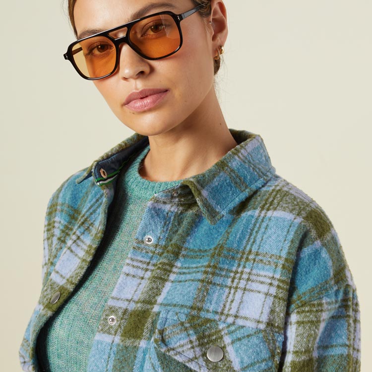 Close up view of model wearing the plaid shacket in lilac/green/blue.