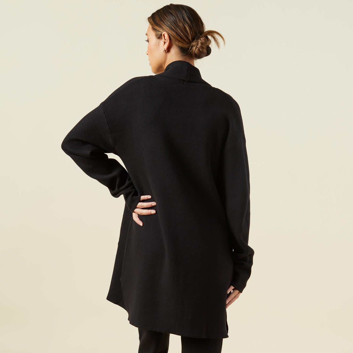 Back view of model wearing the supersoft sweater knit cardigan in black.