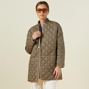 Front view of model wearing the quilted bomber in laurel green.