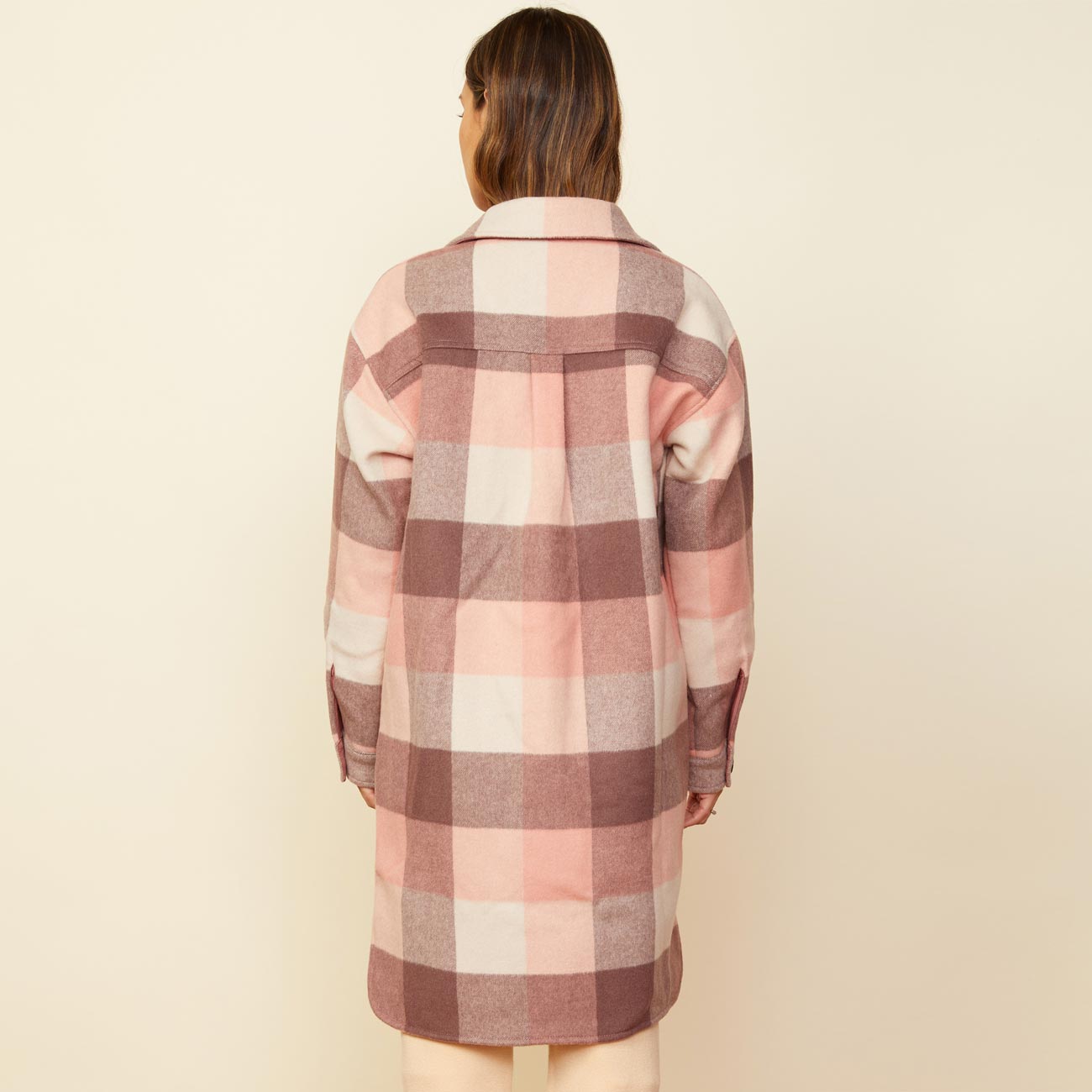 Back view of model wearing the long woolen shirt jacket in pink.