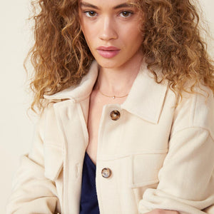 Front view of model wearing the safari jacket in off white.