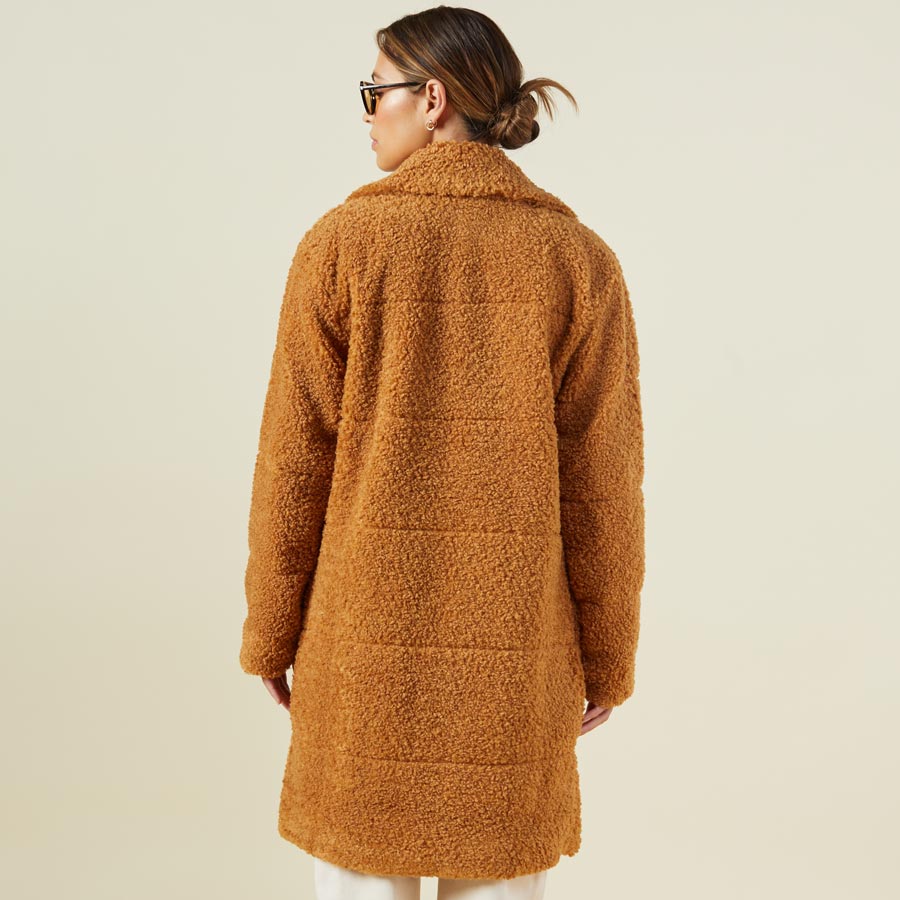 Back view of model wearing the teddy coat in camel.