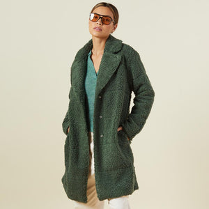Front view of model wearing the teddy coat in forest.
