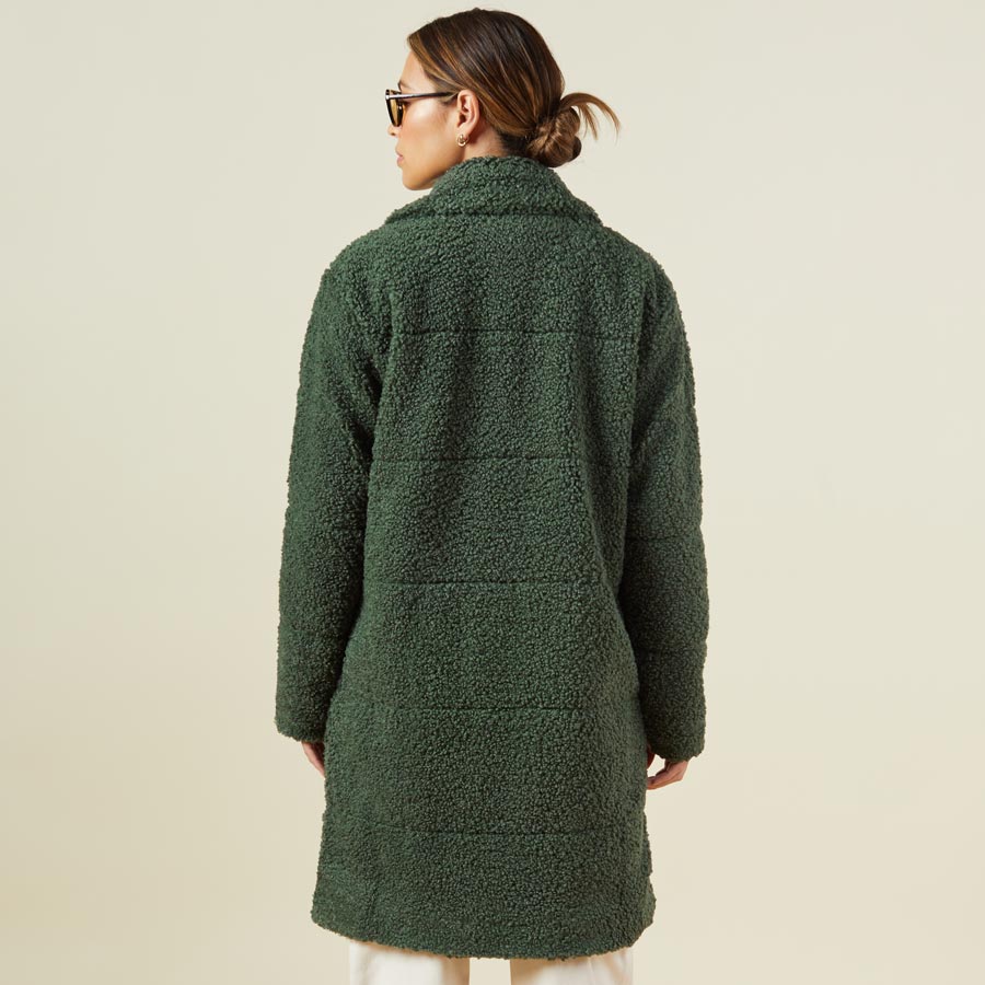 Back view of model wearing the teddy coat in forest.