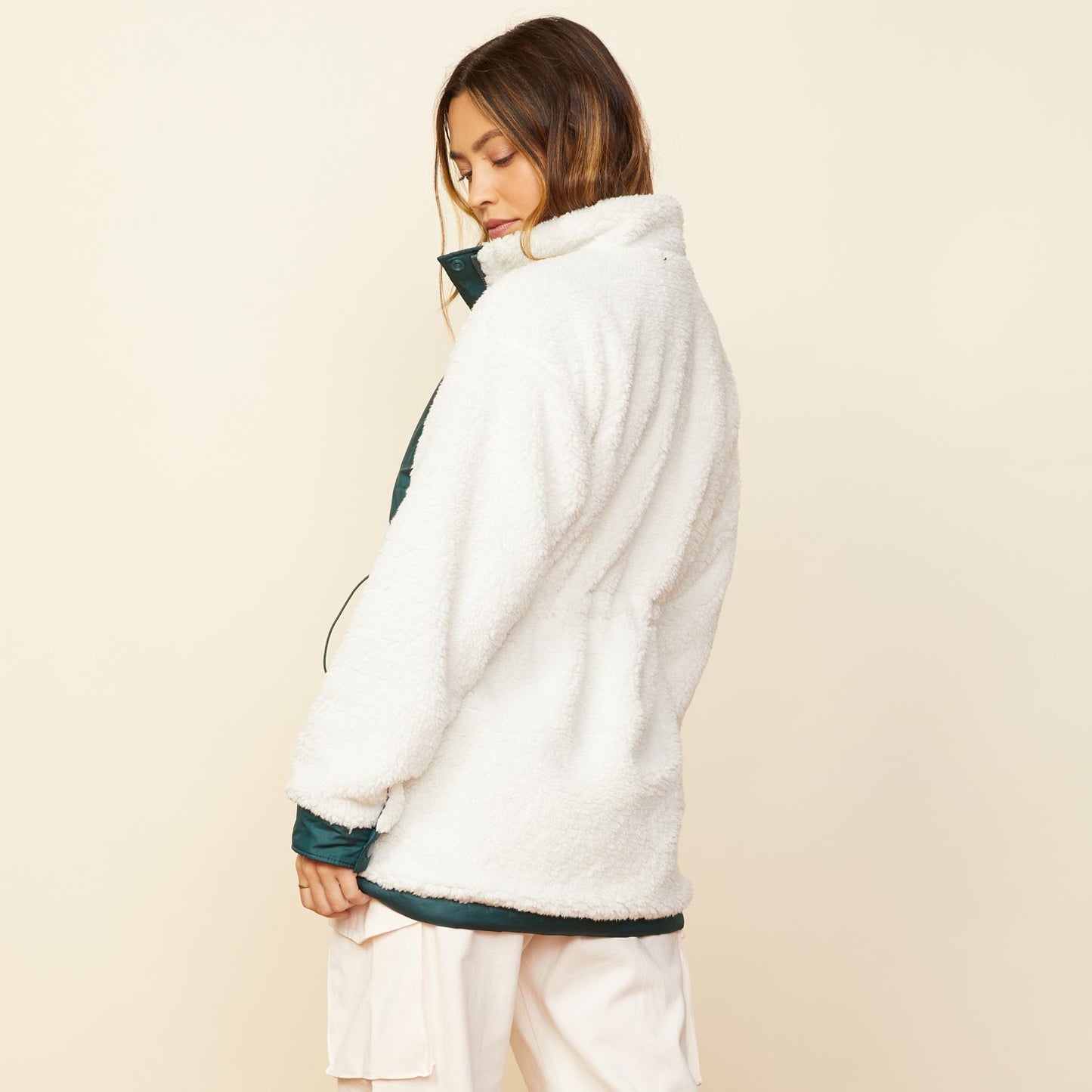 Back view of model wearing the reversible sherpa lined jacket in deep forest.