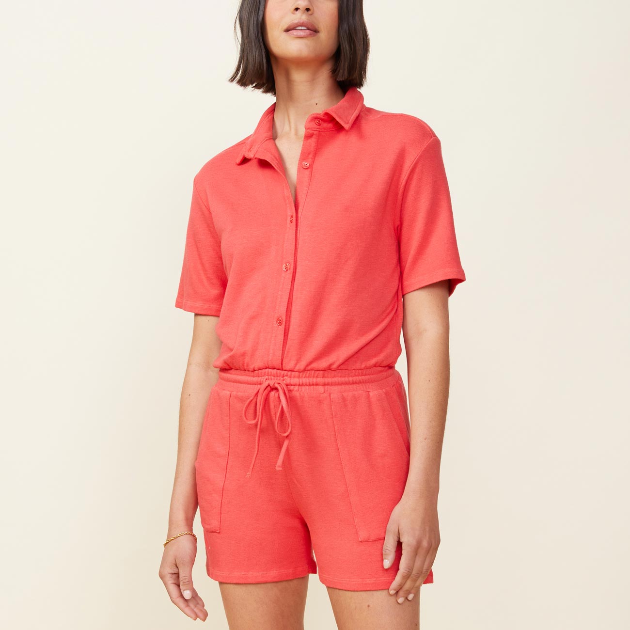 Front view of model wearing the supersoft romper in fire coral.