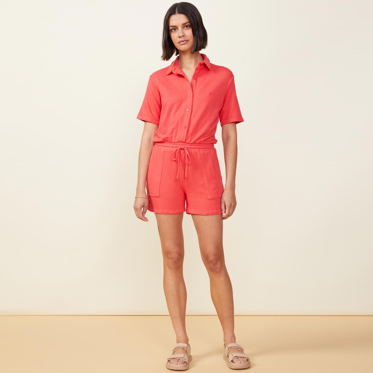 Front view of model wearing the supersoft romper in fire coral.