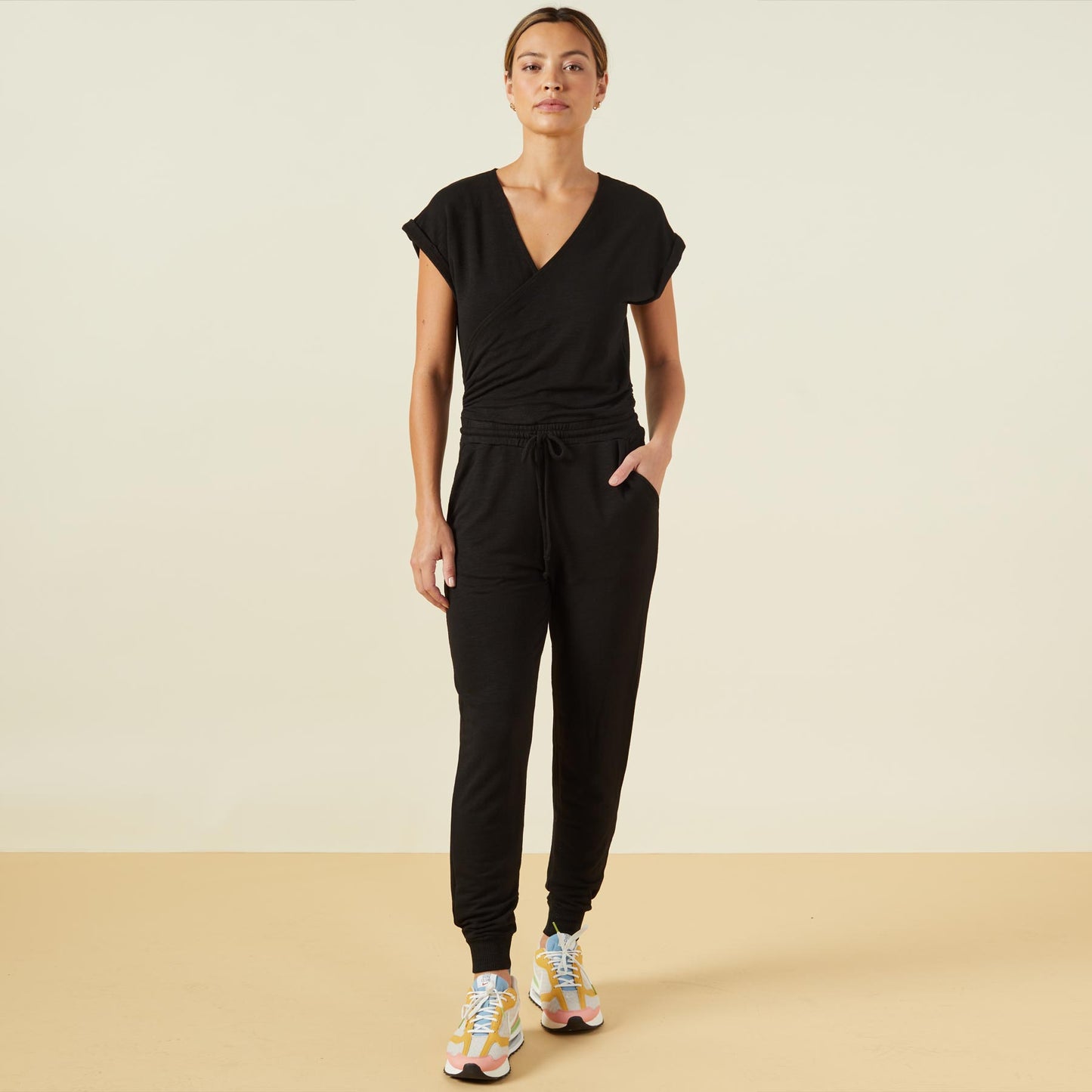 Front view of model wearing the supersoft wrapped jumpsuit in black.