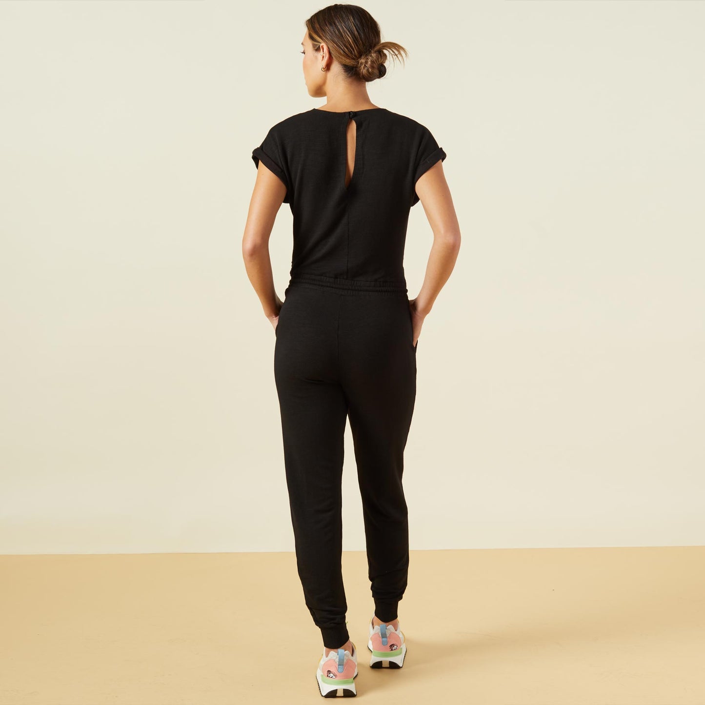 Back view of model wearing the supersoft wrapped jumpsuit in black.