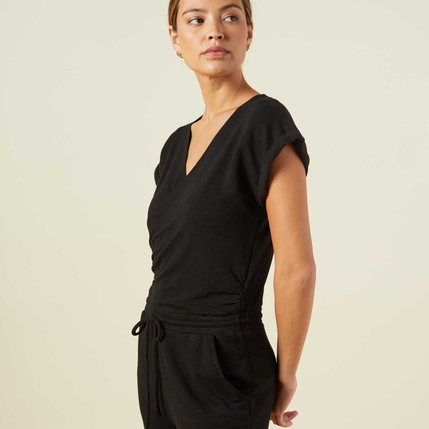 Close up view of model wearing the supersoft wrapped jumpsuit in black.