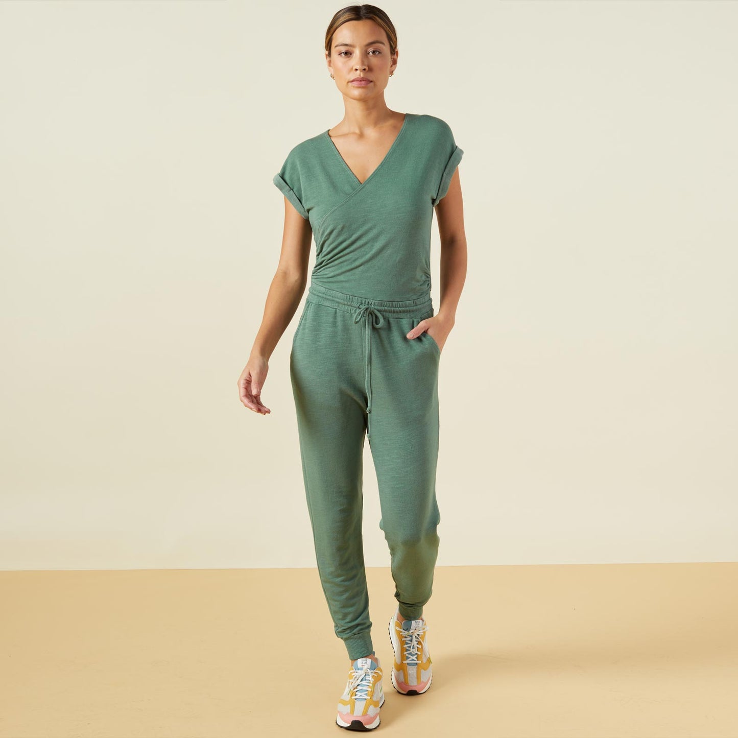 Front view of model wearing the supersoft wrapped jumpsuit in kale green.