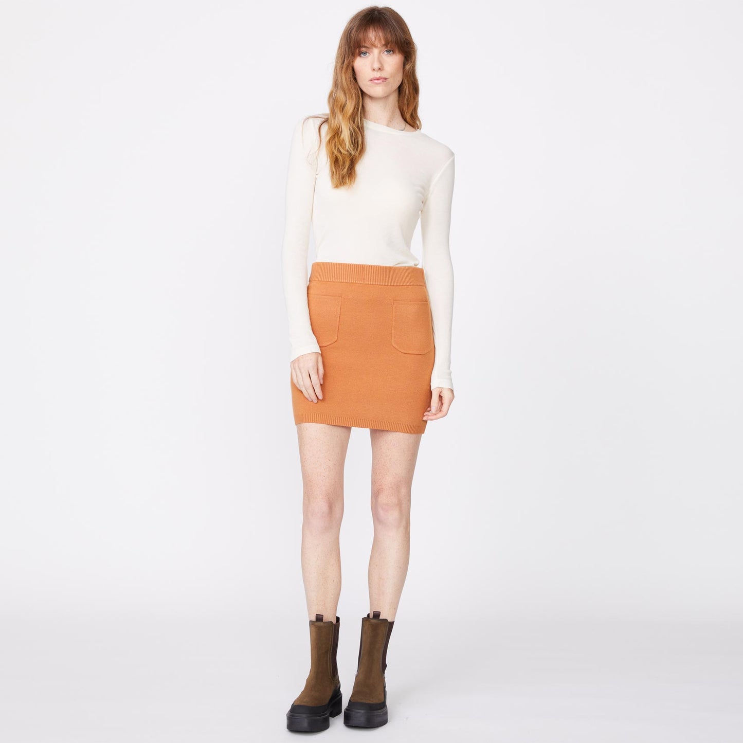 Front view of model wearing the supersoft sweater knit pocket mini skirt in nugget.