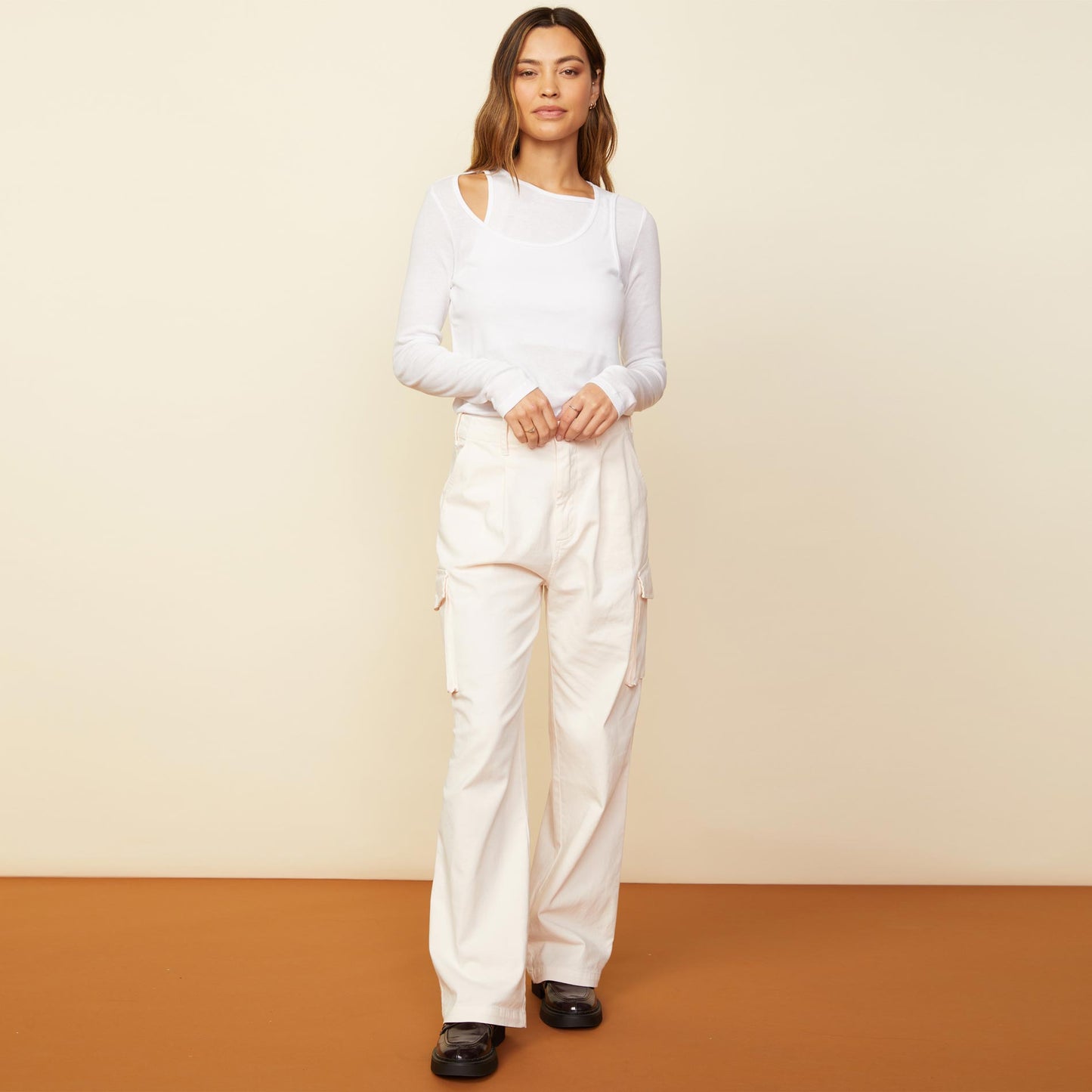Front view of model wearing the asymmetric long sleeve top in white.