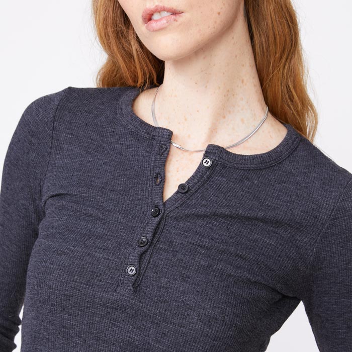 Close up view of model wearing the thermal henley in black.
