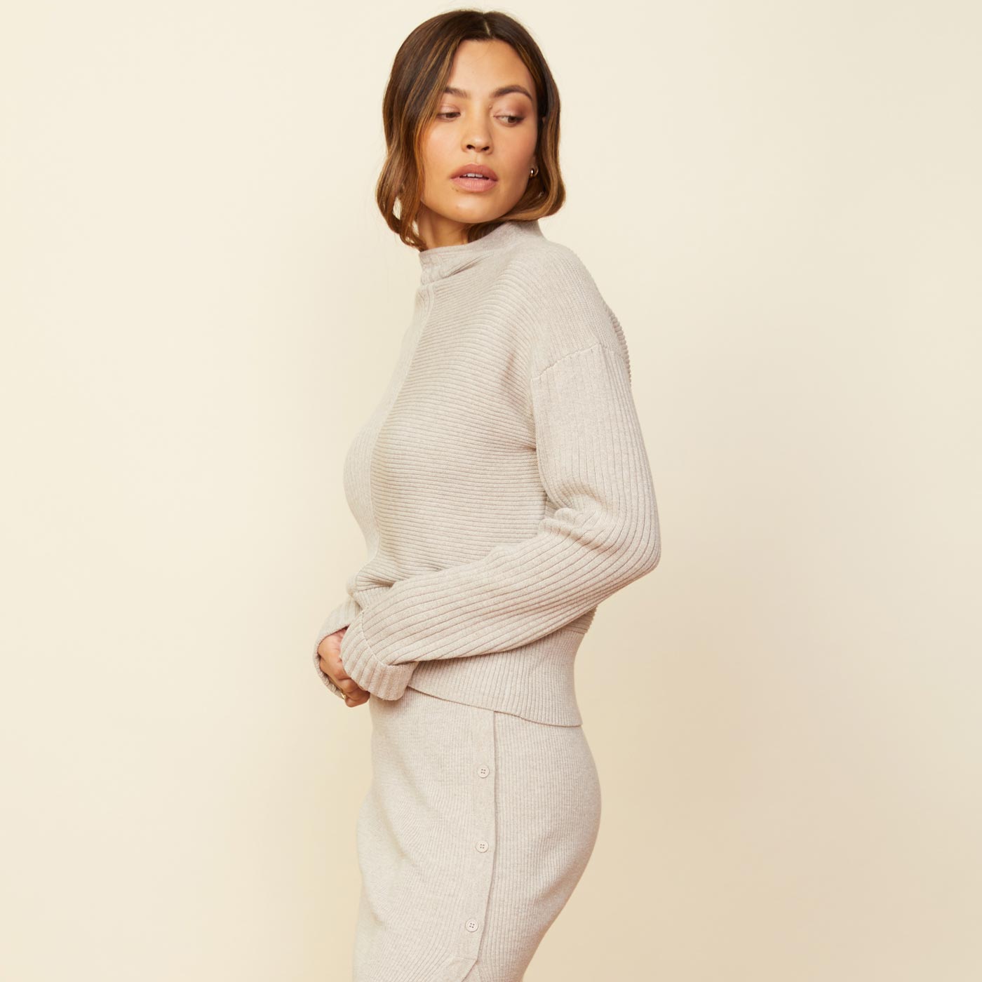 SIde view of model wearing the mock neck rib sweater in ash.