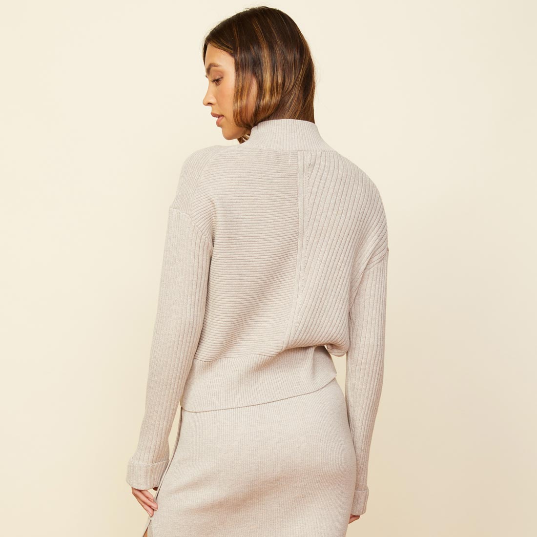 Back view of model wearing the mock neck rib sweater in ash.