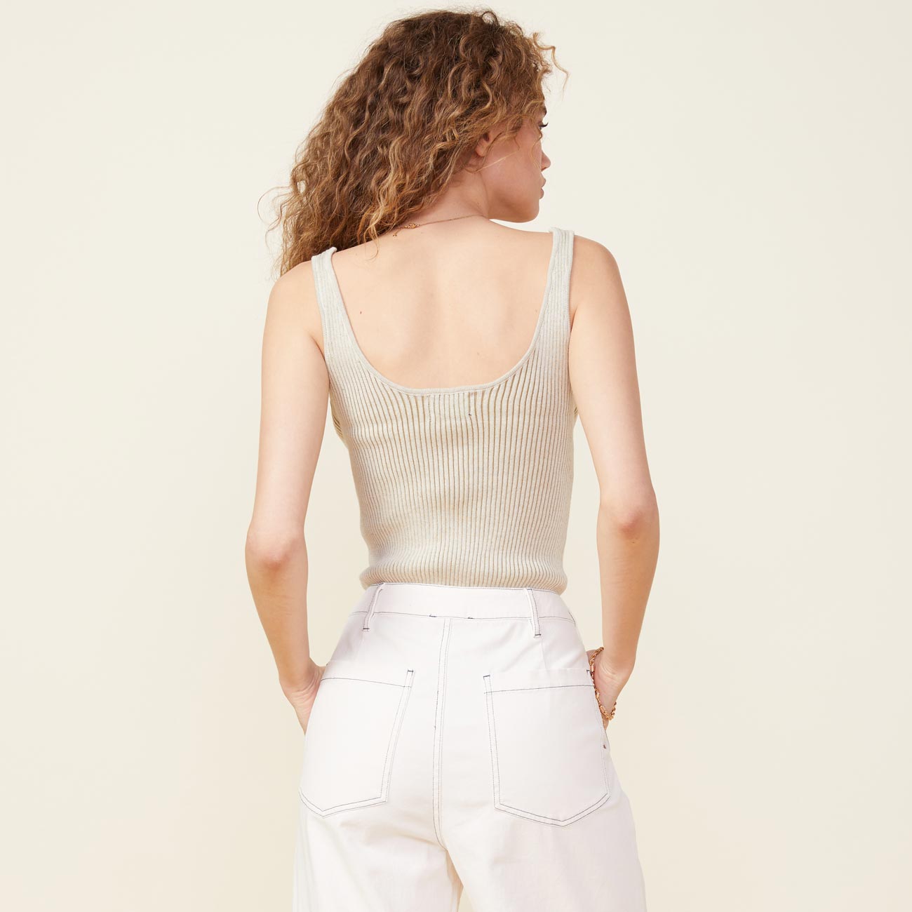 Back view of model wearing the scoop neck sweater tank in buttercream.