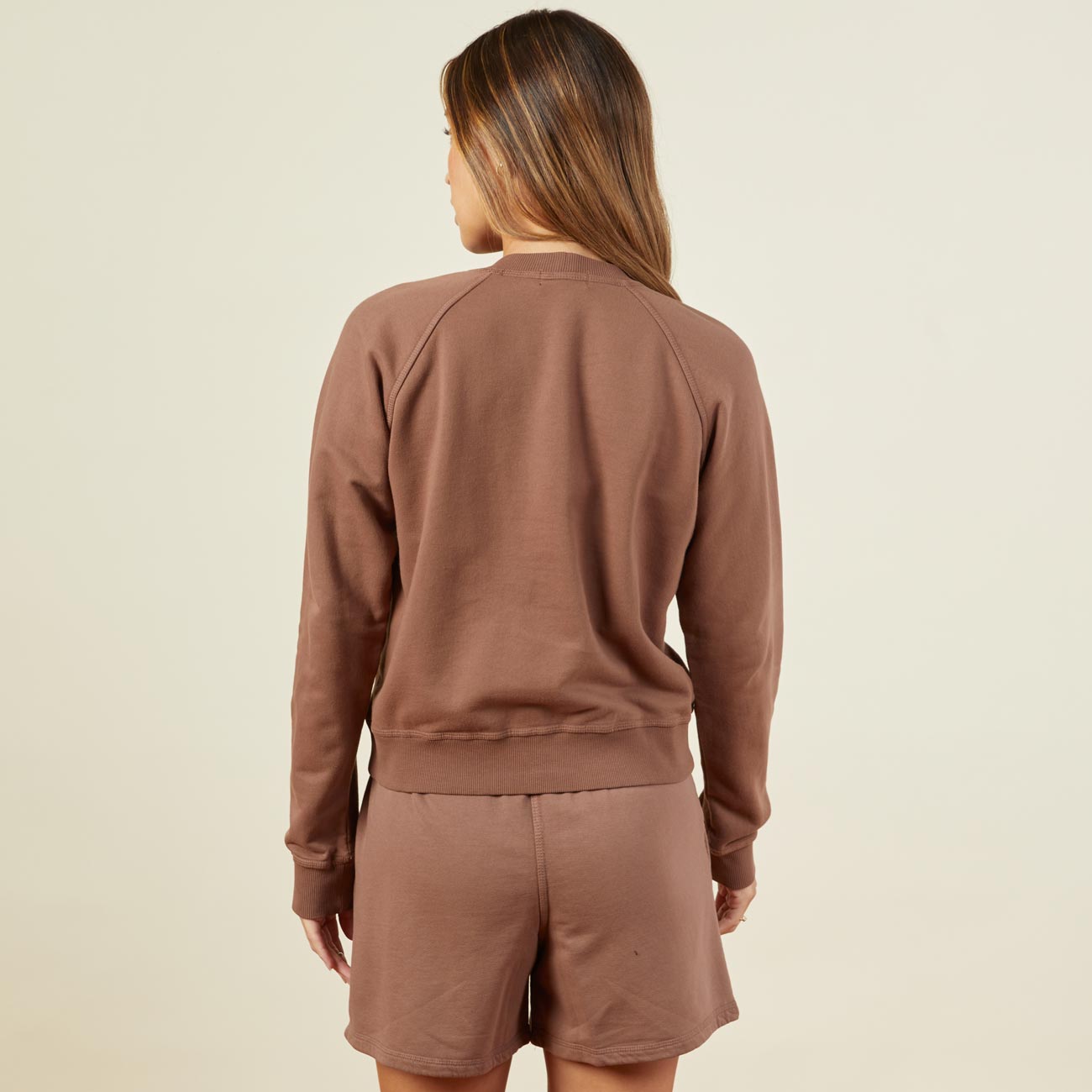 Back view of model wearing the 90's classic raglan in dusty cocoa.